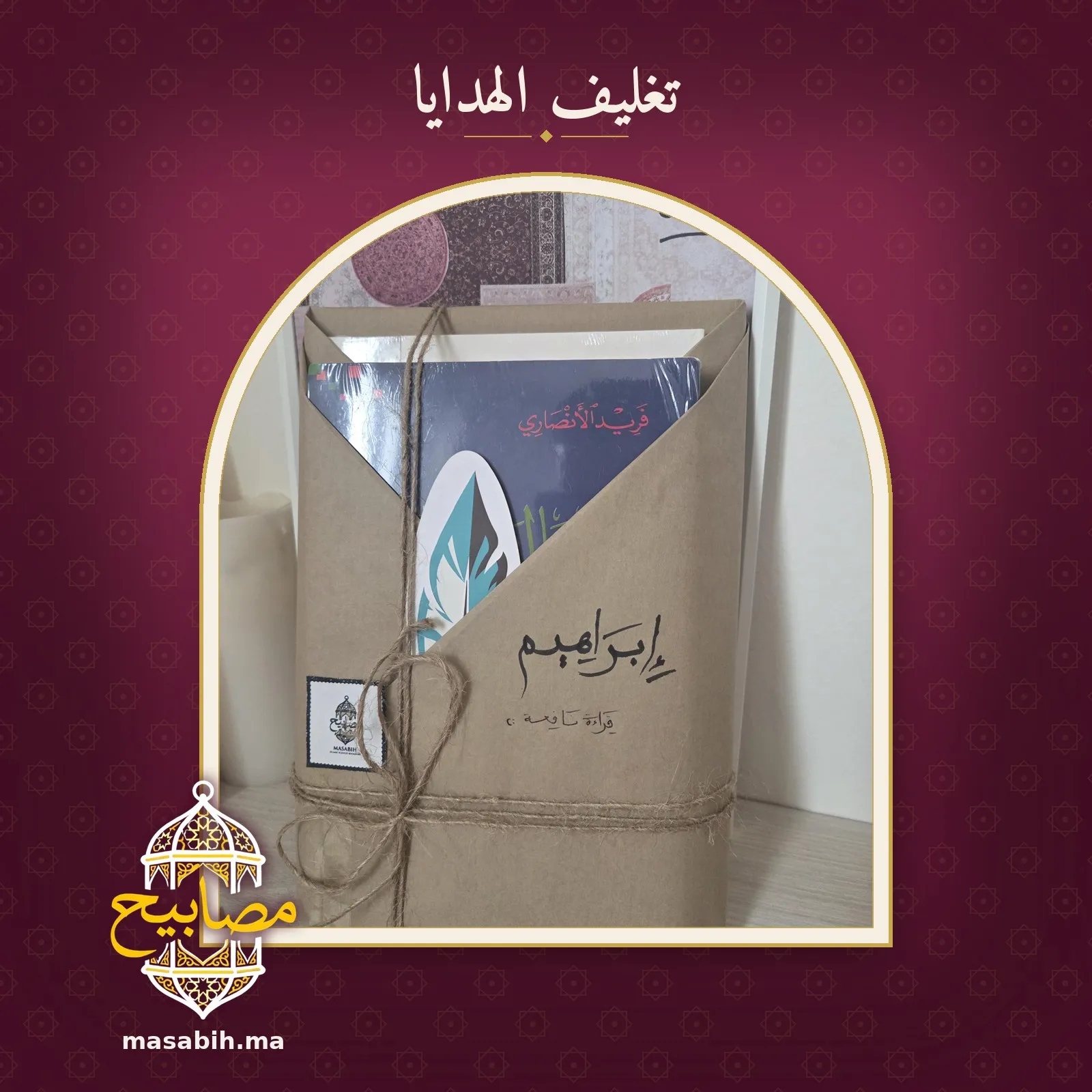 الهدية نفسها قائمةً على رفّ: ورقٌ بنّيّ مطويّ وحبلٌ من القنّب، واسمٌ بخطّ اليد، وطرفُ غلاف الكتاب وفاصلٌ على شكل ريشة